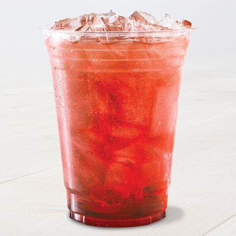 A clear plastic cup filled with a deep red, iced beverage sits on a light surface. The drink appears refreshing.